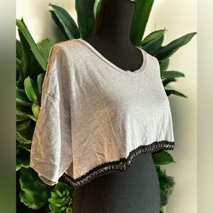 This is a grey cropped t-shirt with black lace and chain trim. By Emma & Sam L